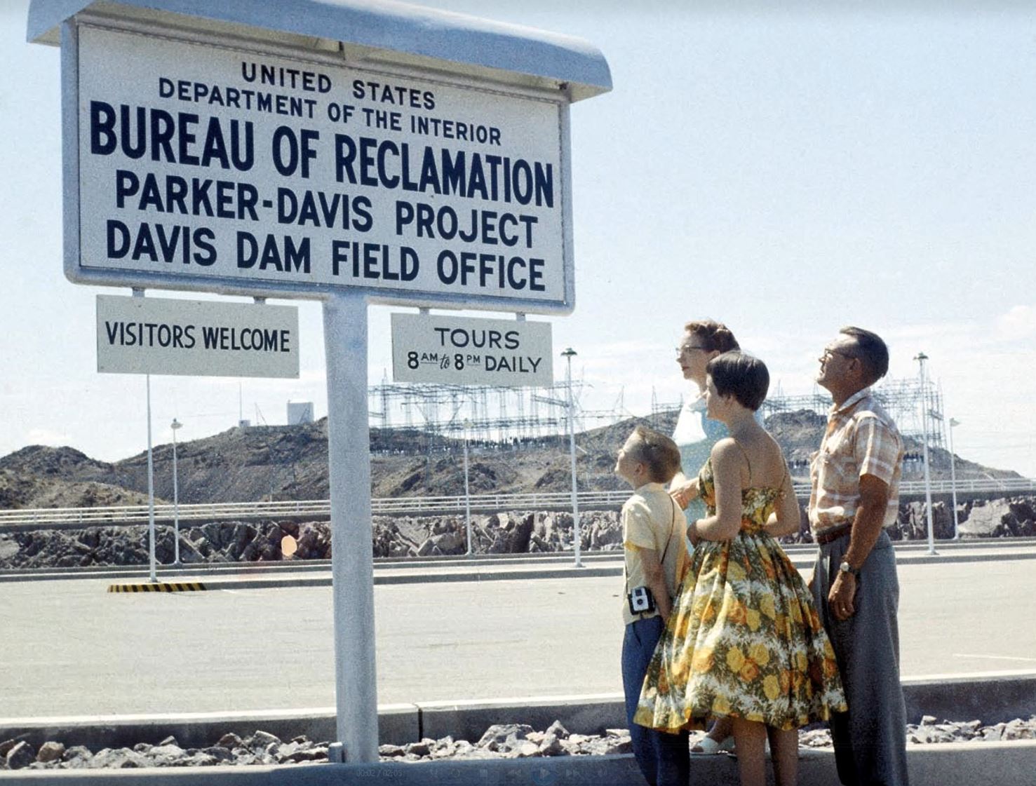 family looks> at Davis Dam entrance sign